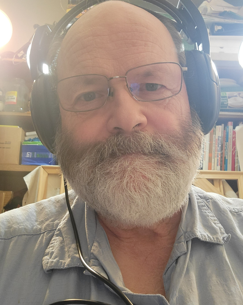 The artist with headphones. Being very hard of hearing does not prevent trying to listen to various kinds of audio. Classical to Christian music and audio books are favorites while in the studio. Photo taken September 2021